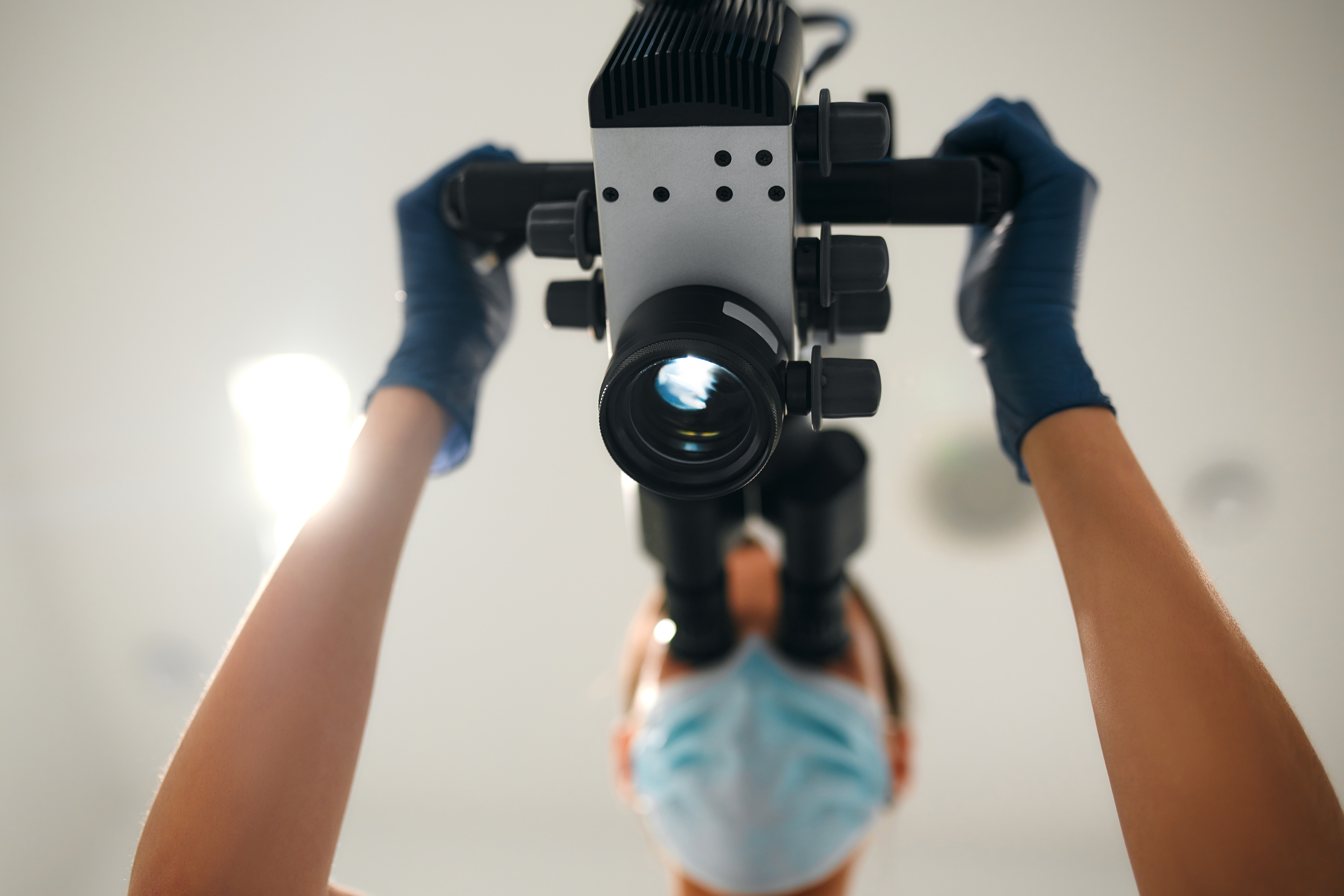 Dentist using advanced dental technology, featuring a microscope for precision and innovation in modern dentistry.