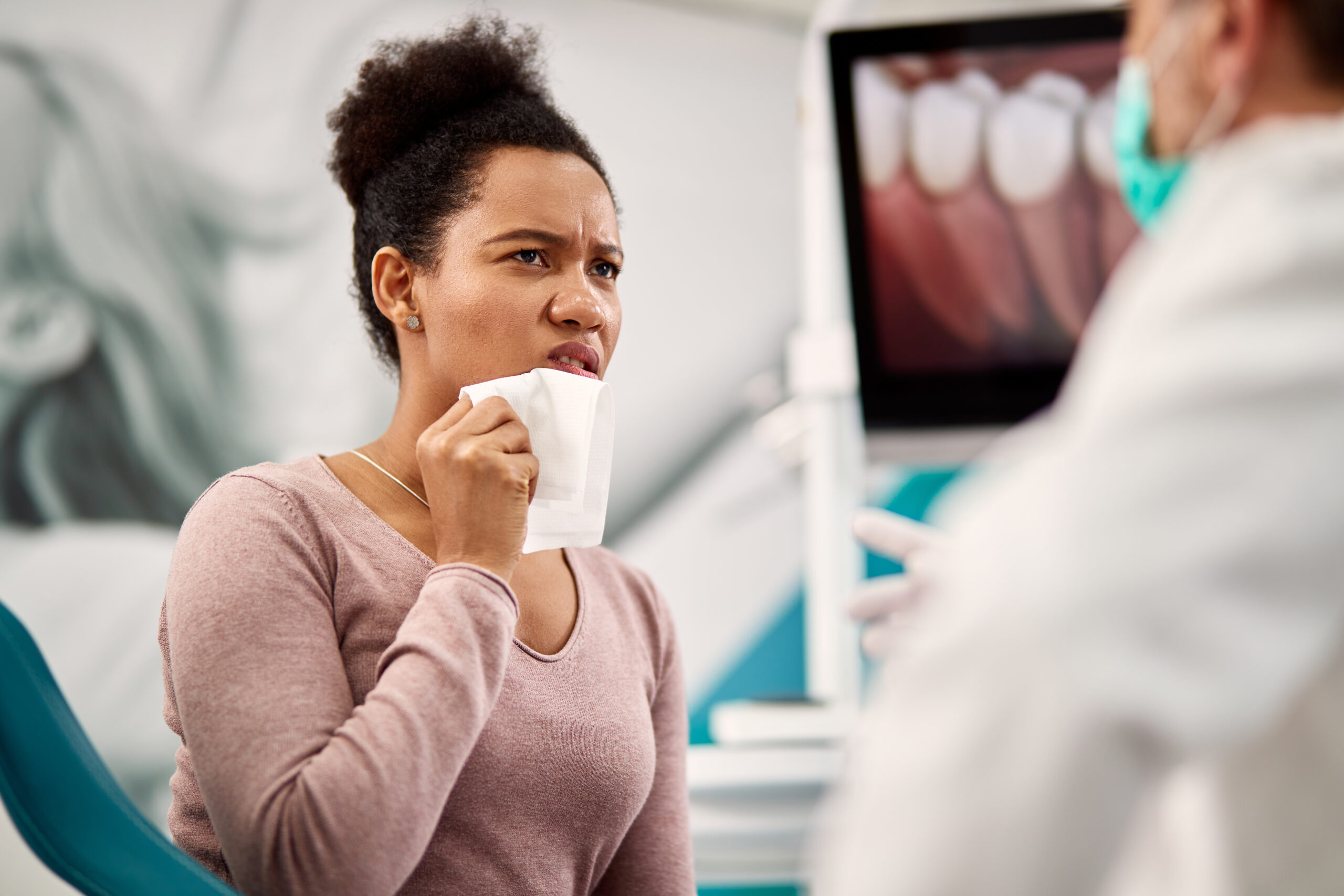 Dentist discussing dry mouth treatment options with a patient in a clinic setting.